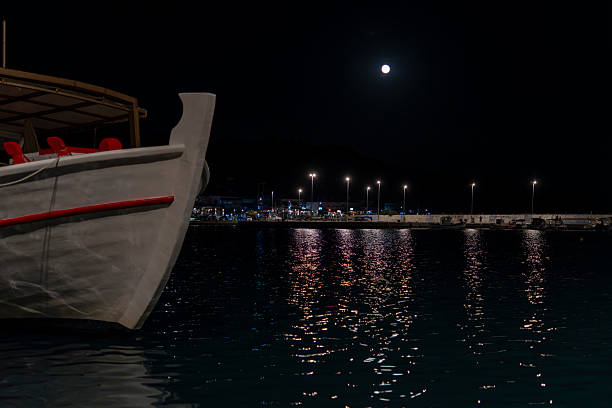 istock A boat is in the water with a full moon in the background 2245446029