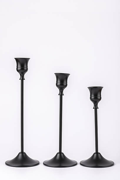istock Three black metal candle holders in vertical position on white background, minimalist and elegant design. Concept of home decor and slow living 2245446035