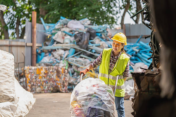 istock An Asian woman uses a cart to pull and sort trash for recycling. 2245453286
