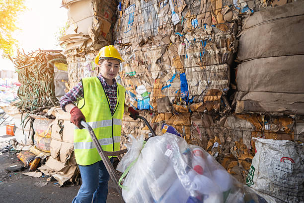 istock An Asian woman uses a cart to pull and sort trash for recycling. 2245453298