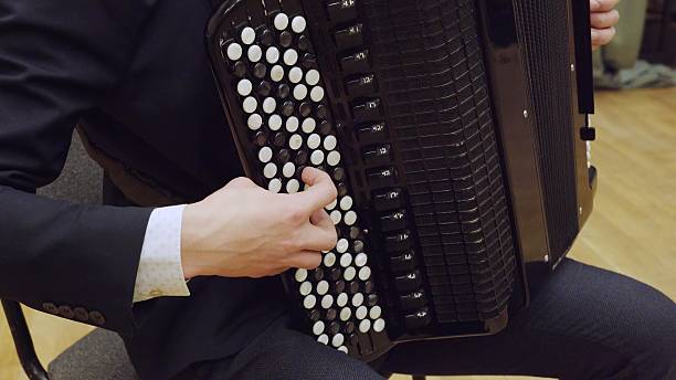 istock Musician playing black accordion with white keys close up 2245456494