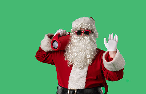 istock Santa Claus dancing cheerfully with a portable speaker on a green chroma key background 2245457576