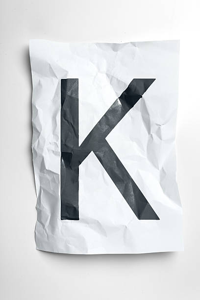 istock Crumpled paper featuring a large black letter K on a white background 2245457805
