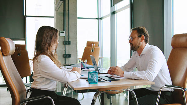 istock Business meeting between colleagues make a deal and shake hands in a modern office setting during the day discussing project details and strategies with laptops and documents 2245458464