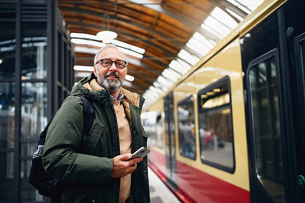 istock Happy Middle-Aged Man Checking His Phone with a Train Approaching at a Berlin Hackescher Markt Station 2245458613