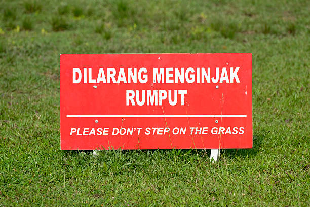 Warning sign with text Please Don't Step on the Grass in a public park