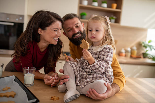 istock Girl Eating Cookie While Parents Smile 2245460628