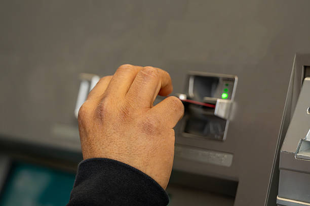 istock Hand inserting a debit card into an ATM for a transaction 2245464692
