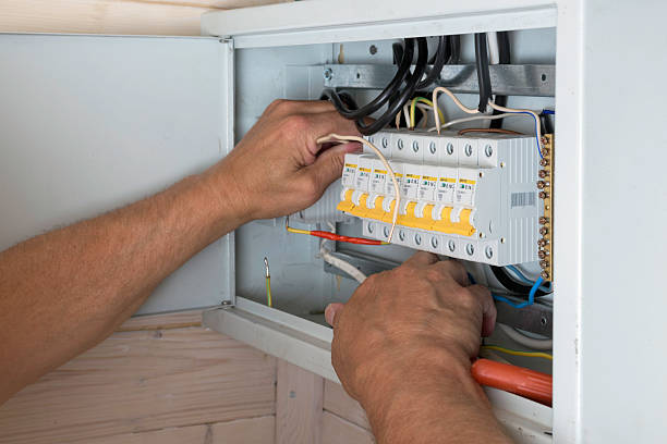 istock Electrician's skilled hands install wires inside distribution board, ensuring reliable and safe electrical connection in new home. 2245464869