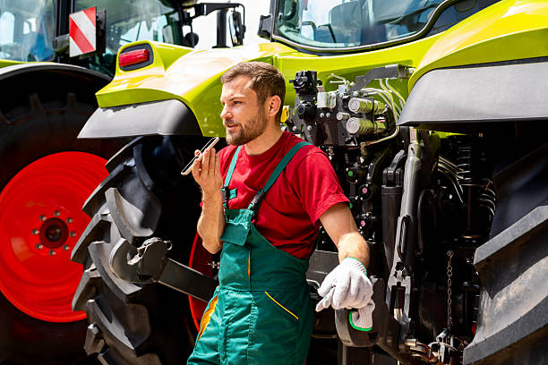 istock Agricultural machinery technician recording voice message using his smartphone near tractor outdoors 2245465631