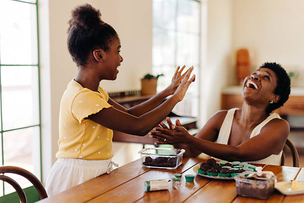 istock Fun brigadeiro making: Mother and daughter laughing happily while preparing chocolate truffles for a birthday 2245466494
