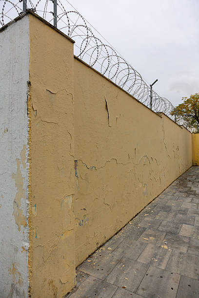 istock Texture of a brick wall with old, peeling paint in some partially ruined buildings 2245468732