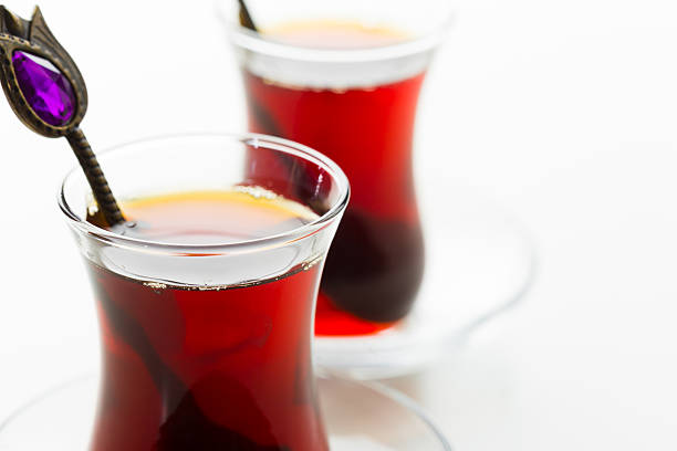istock Warm tea served in elegant glass cups with decorative spoons on a light background 2245469264