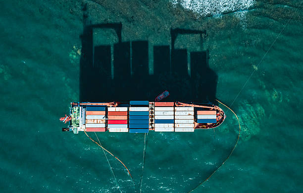 istock Aerial top down view of a container cargo ship stands aground after a storm with floating boom around the ship to prevent the spread of petroleum. 2245469273