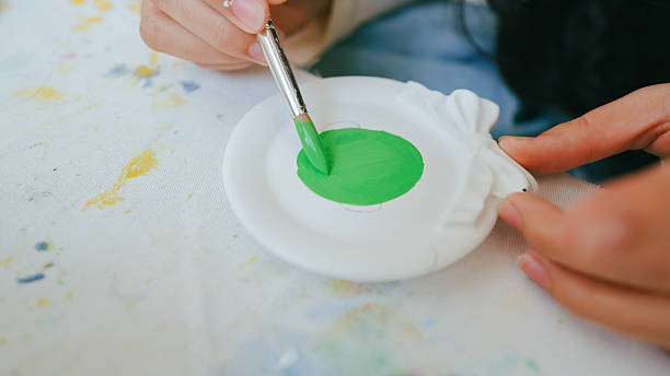 istock Hand painting on white plaster craft with green acrylic paint, representing creativity, hobby, and artistic expression in DIY arts. 2245470444