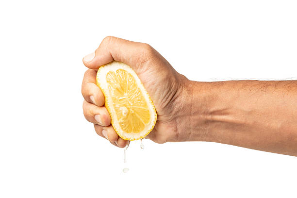 istock Male hand squeezing a lemon isolated on white background 2245470523