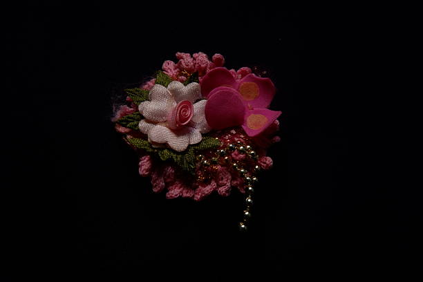Brooch handmade in the form of flowers beige and blue color is attached to the female blouse