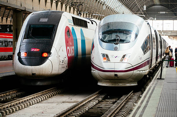 Seville Santa Justa railroad station, Spain - 26 October, 2025: Two high speed trains, one belonging to Ouigo and another one to Renfe AVE