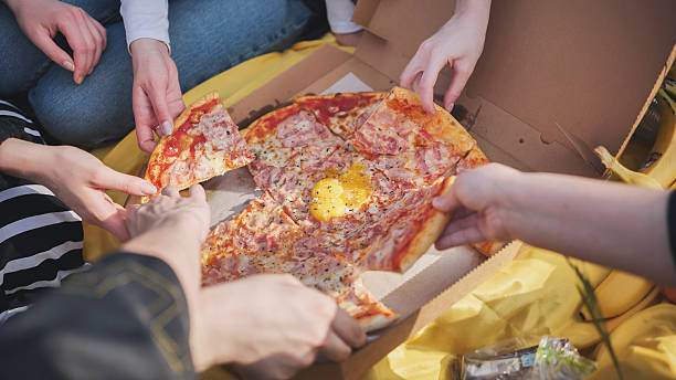 istock A group of hands reach for the pizza. 2245475502