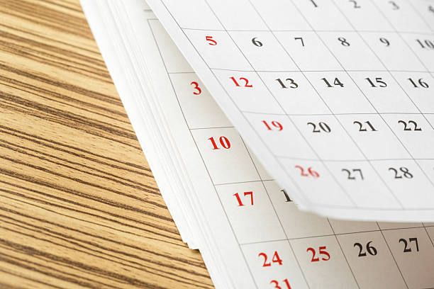 istock Calendar pages displaying dates on a wooden table during daylight hours 2245475775