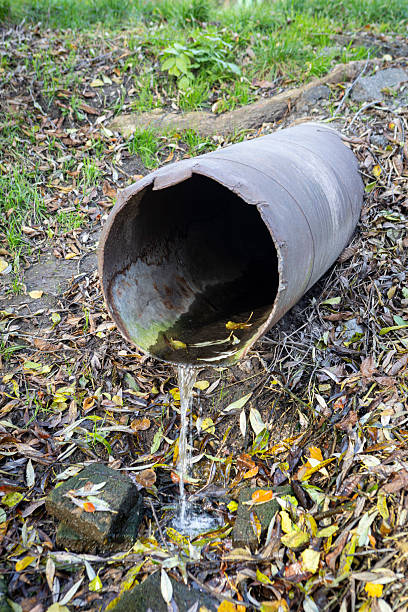istock An old iron drain pipe with water leaking out of it 2245475833