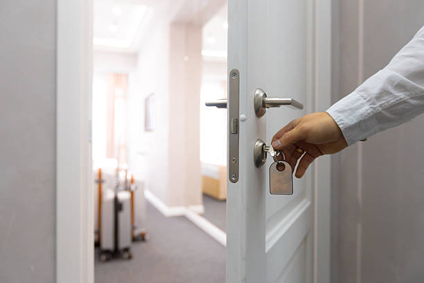 istock Person unlocking a door in a modern hotel hallway during a daytime visit 2245476954
