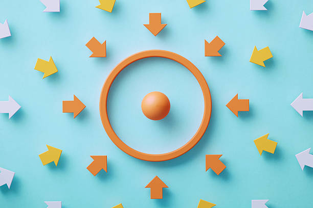Colorful arrows gravitated towards an orange colored target symbol on blue background. Business target and target market concept.