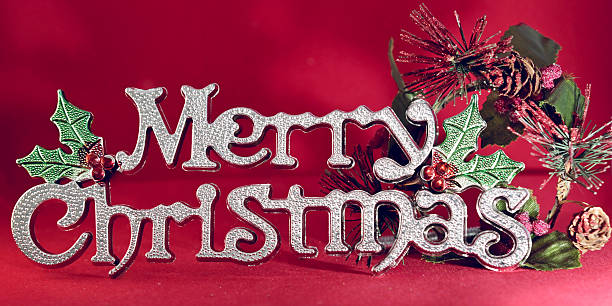 Merry Christmas silver wording with Mistletoe wreath at the end of the words on red background