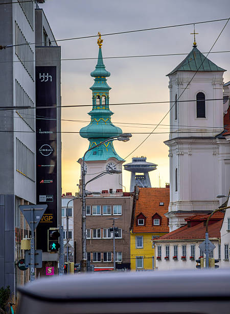 Bratislava, Slovakia - October 20, 2025: Cityscape with clock tower of Michaels Gate - Michalska brana - at sunset. In background UFO Tower and observation desk.