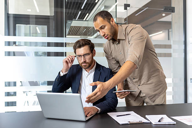 istock Focused businessmen engage in a collaborative meeting, discussing a project in a modern office setting. 2245479931