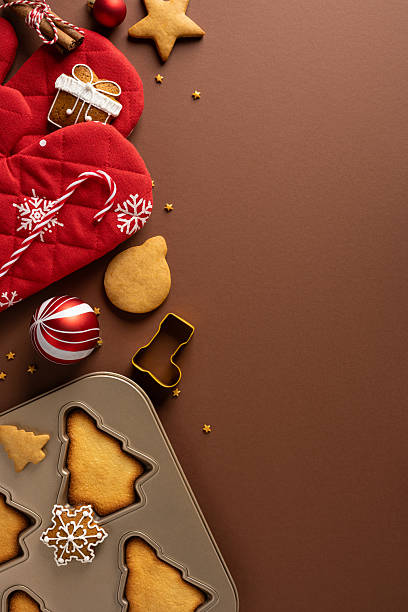 istock A vertical festive Christmas scene featuring a red mitten, cookies, candy canes, and ornaments arranged on a brown surface, suggesting home baking, holiday gifts, and seasonal celebration 2245480515