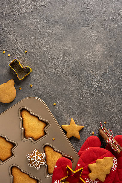 istock Vibrant vertical holiday scene featuring a metal baking tray filled with tree and star cookies, plus red mittens, twine and a snowflake decoration, capturing Christmas and New Year warmth 2245480525
