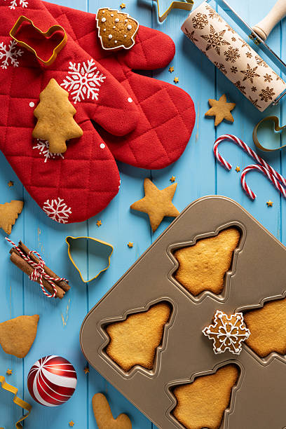 istock Vibrant top view vertical Christmas and New Year baking scene with red mitts, cookie cutters, stars, and candy canes on a bright blue surface perfect for holiday greetings and seasonal cuisine imagery 2245480534