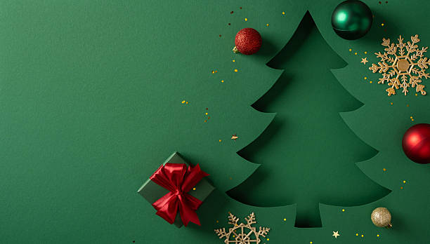 istock A green backdrop hosts a sculpted Christmas tree silhouette, a red gift with ribbon, and decorative ornaments 2245480546