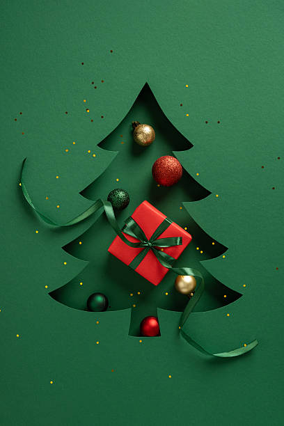 istock A green cutout Christmas tree card features a red gift with a dark green ribbon, creating a festive scene suitable for Christmas and New Year greetings, decor and seasonal mailing 2245480566