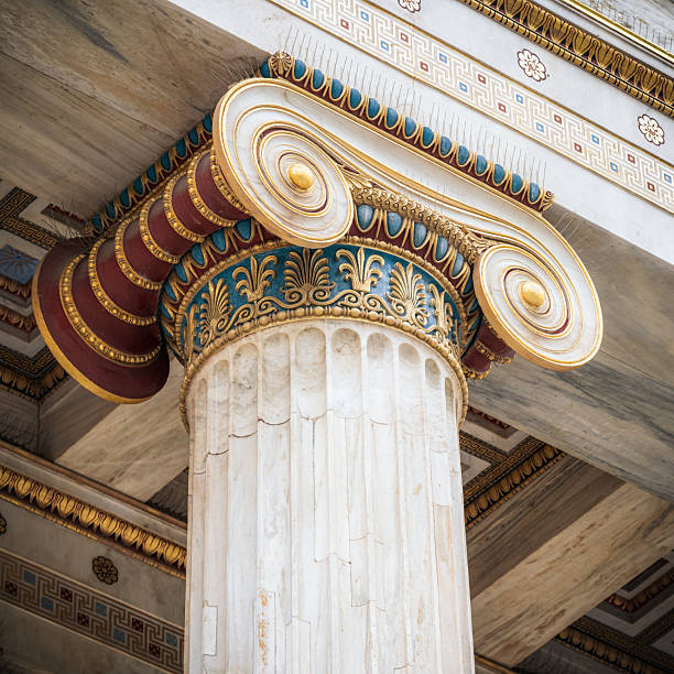 Close up of the top section of an intricately decorated marble Ionian column at the national Academy of Athens in the city's centre.