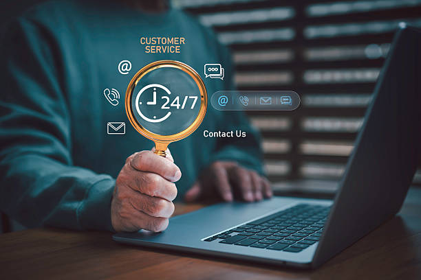 istock 24/7 customer service concept with magnifying glass and laptop, representing online communication, call center, email, and support contact. Ideal for business technology and digital marketing themes. 2245484165