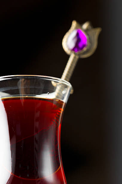 Colorful tea served in a clear glass with decorative spoon highlighting a beautiful drink moment
