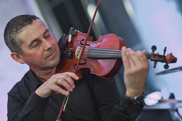 istock Violinist In Black Shirt Performing Live Session With Focused Expression 2245484428
