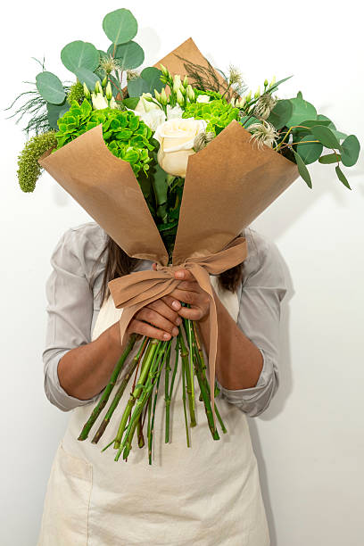 istock Woman's hands holding bouquet of white roses 2245488782