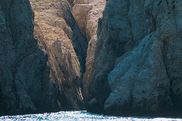 Sunlit rocky cliffs with sea view natural coastal landscape formation.