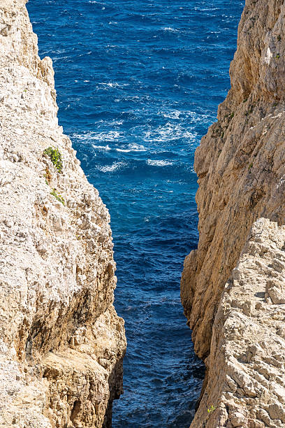 istock Cliffside view of deep blue sea between rugged rock formations 2245490362