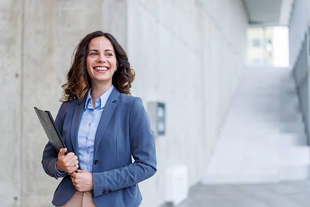 istock Professional businesswoman smiling looking away holding folder 2245492532