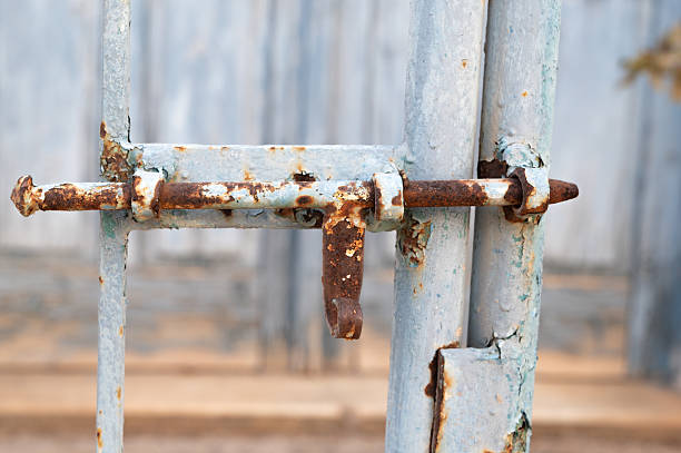 istock Rusty gate latch, Old weathered latch and corroded gate locking mechanism, Abandoned gate featuring rusted latch and deteriorated locking hardware consistent with neglect 2245494172
