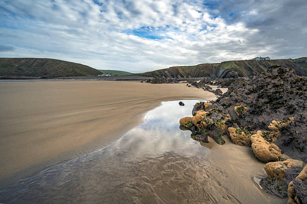 Northcott Mouth rocks and sand seen at low tide Cornwall UK