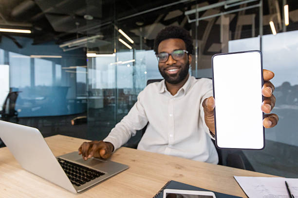 istock Businessman Displaying Smartphone Screen in a Modern Office Setting 2245496687