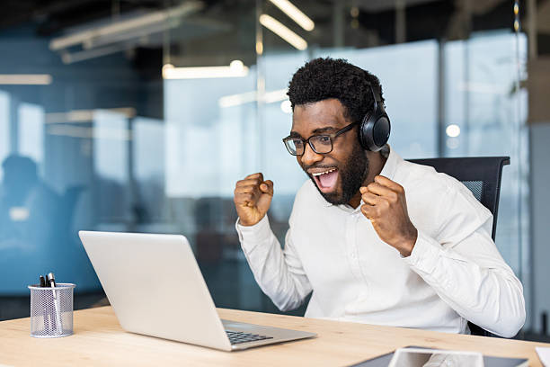 istock Excited man celebrating success while working on a laptop in an office 2245496691
