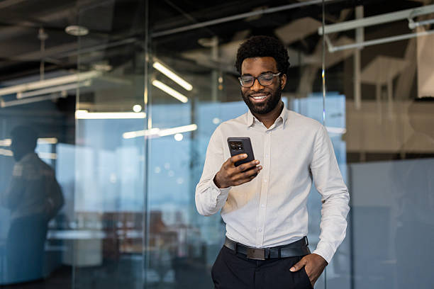 istock Happy businessman smiles while looking at his phone in the office. 2245496743