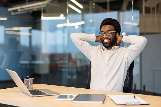 istock Happy businessman relaxing at desk in modern office 2245496753