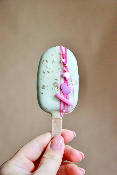 istock minimalist dessert—a hand holding a popsicle coated in  chocolate or icing 2245497259
